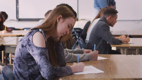 Gruppe-Von-College-Studenten-Am-Schreibtisch-Im-Klassenzimmer,-Die-Einen-Test-Ablegen