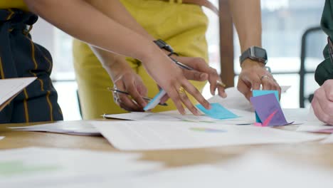 mujer escribiendo en una nota post-it durante la reunión