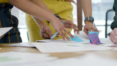 woman writing on post it note during meeting