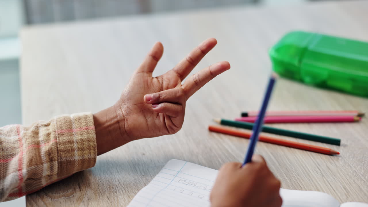 Child learning to count with fingers at a desk