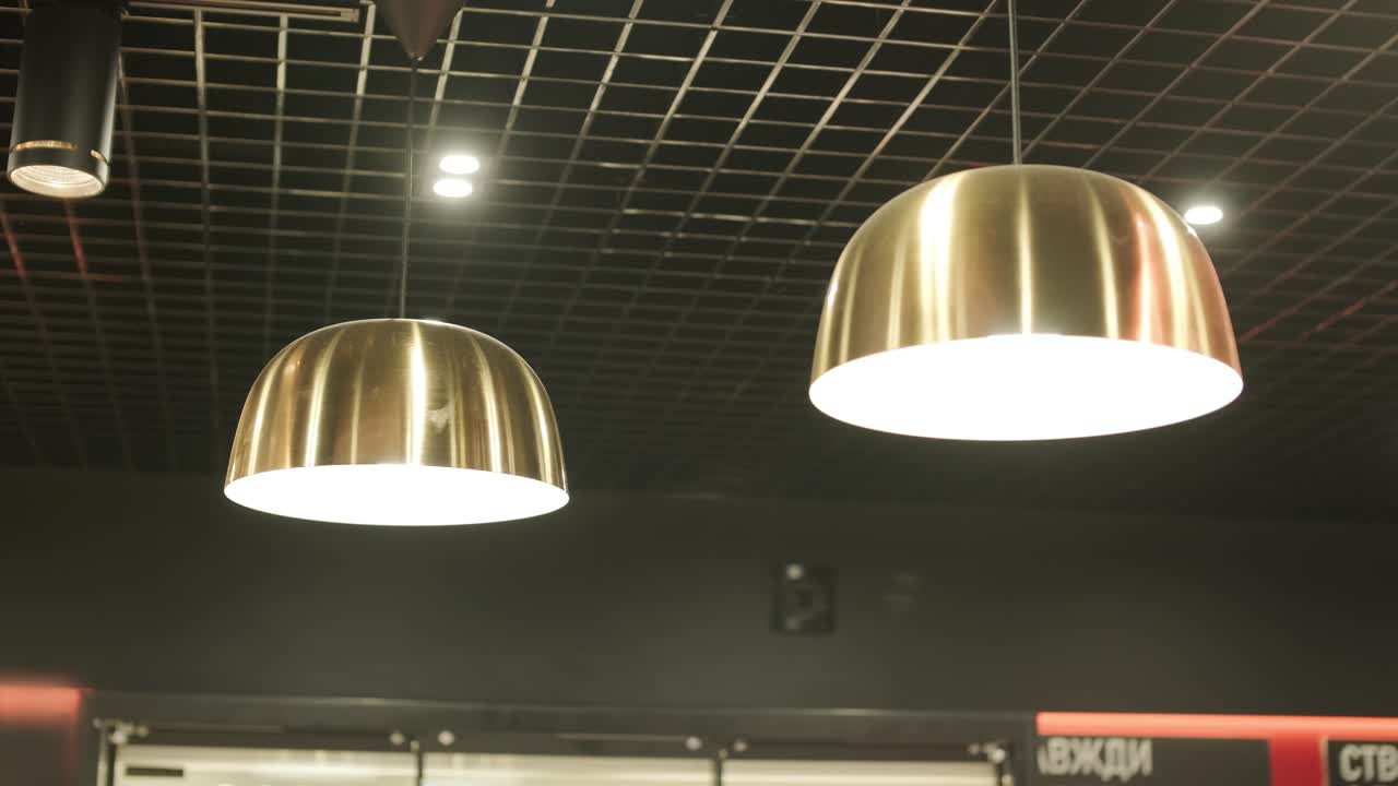 techo moderno con patrones de cuadrícula, iluminación empotrada, lámparas colgantes y un sistema de ventilación. diseño elegante y contemporáneo en un espacio comercial o minorista
