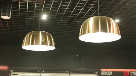 modern ceiling featuring grid patterns, recessed lighting, pendant lamps, and a ventilation system. sleek, contemporary design in a retail or commercial space