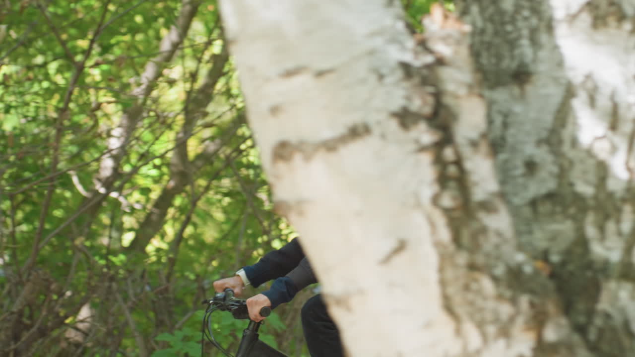 white male courier cycling through foliage, delivering food in insulated backpack along shaded urban trail, sunglasses and helmet, steady pace and focused expression, dappled sunlight on leaves