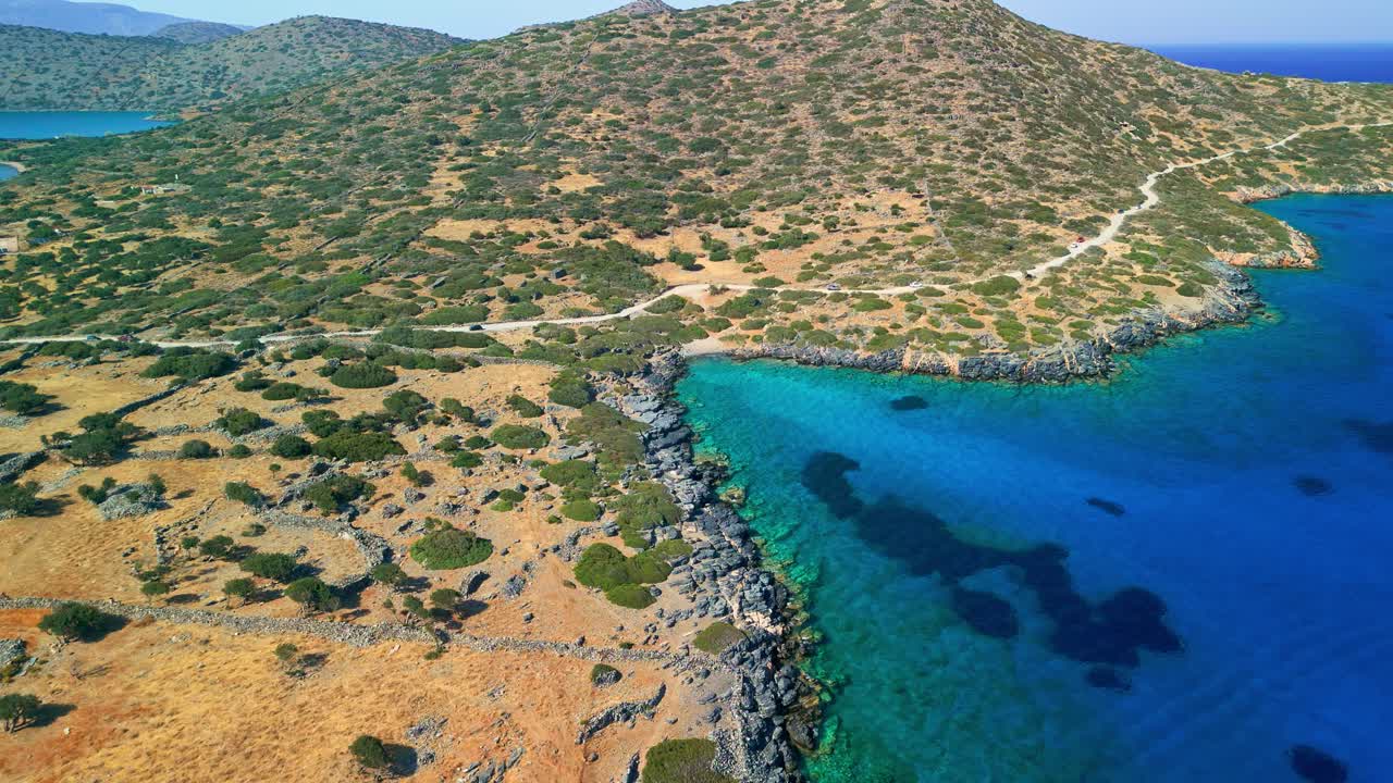 Summer aerial view of rocky coast, and turquoise Aegean waters near Elounda.