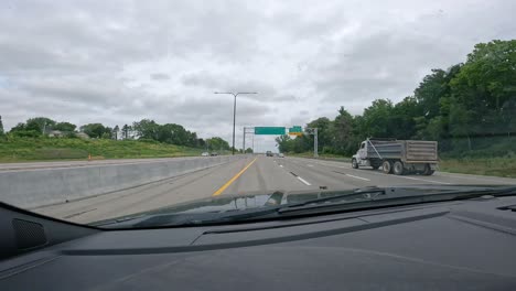 punto de vista mientras conduce por la carretera interestatal 74 a través de las ciudades cuádruples de iowa, acercándose a una rampa de salida con poco tráfico