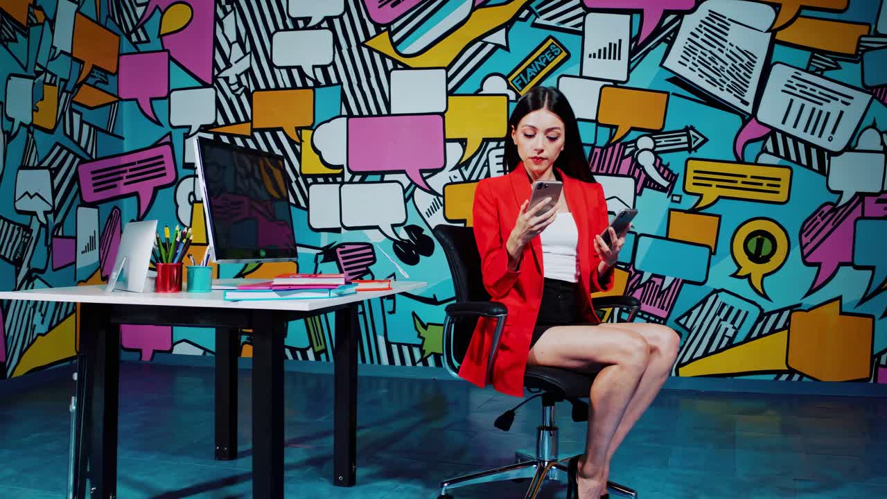 Donna in blazer rosso che usa smartphone in un ufficio moderno