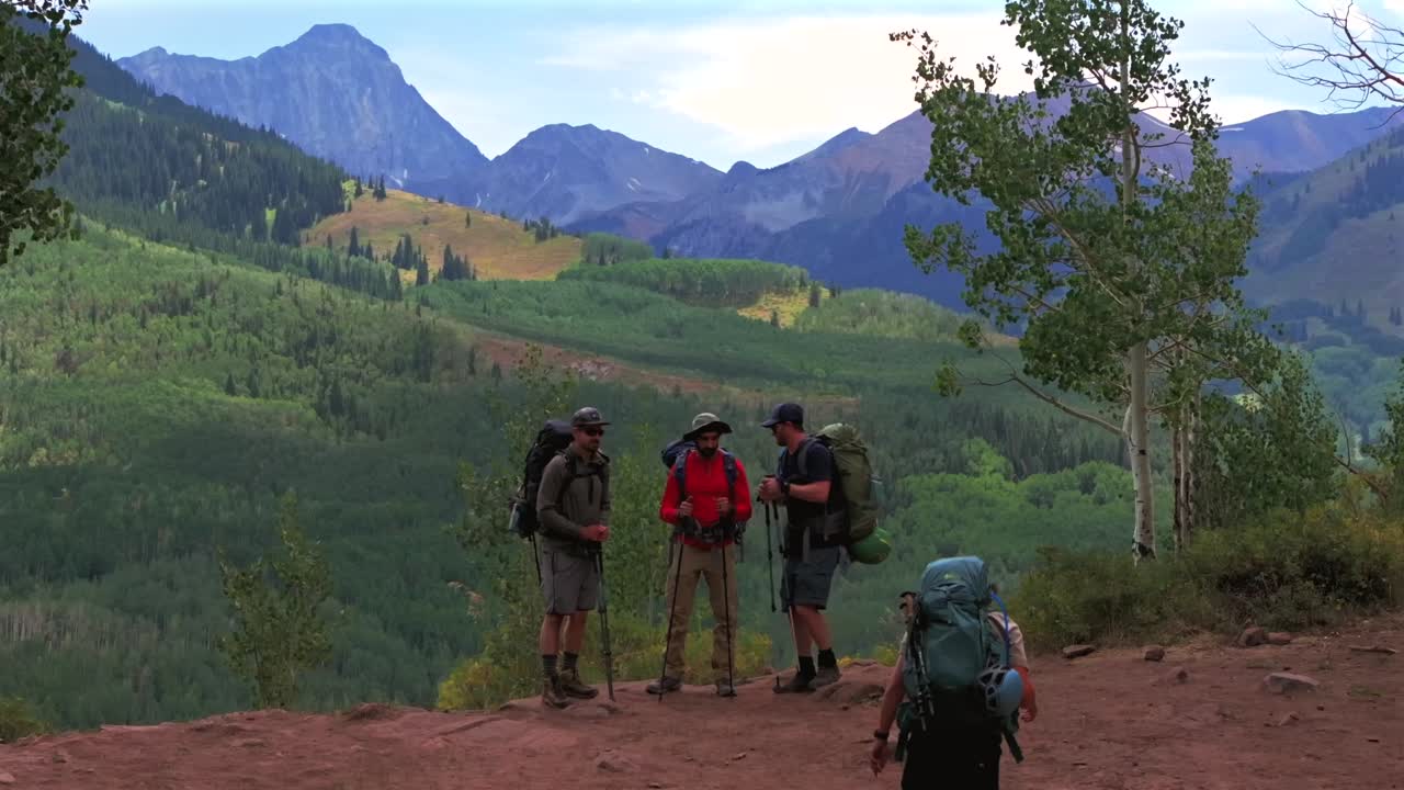 Hiker backpackers people Capitol Peak Creek Trailhead Aspen Snowmass wilderness aerial drone White River National Forest spring summer morning daytime sunny blue skies clouds Rocky Mountains 14er