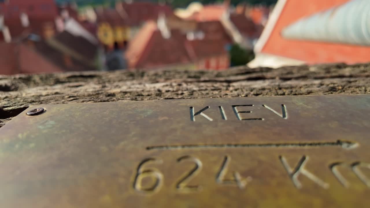 Close-up of a brass plaque indicating the distance to Kiev, Ukraine from the Clock Tower in Sighișoara, Romania