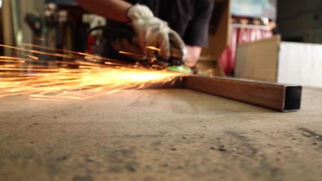 male worker using electric grinder in workshop