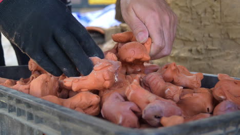 handheld close up of southeast asia clay figurines placed into full crate, than ha hoi an vietnam