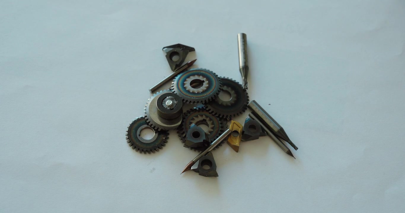 Hands organizing carbide inserts and small metal cutting tools, representing precision engineering and manufacturing processes.