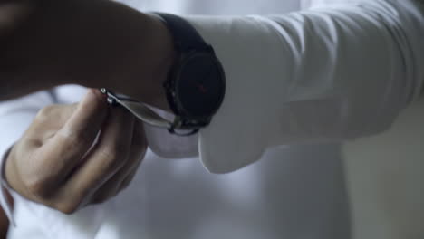 close up of man in dress shirt putting on watch