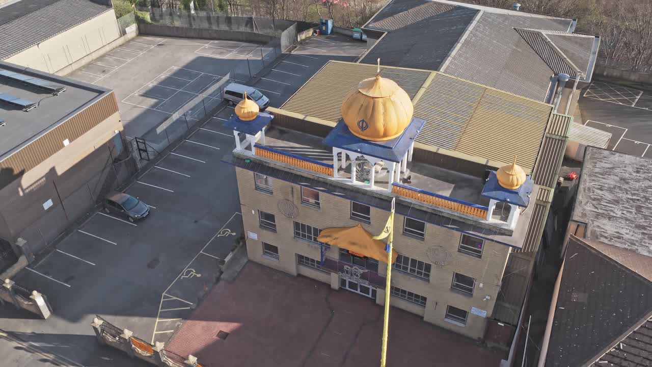 Tempio Sikh Guru Nanak Gurdwara su Halifax Old Road, Huddersfield, Kirklees, West Yorkshire, Inghilterra, Regno Unito, con cupole dorate e bandiera Nishan Sahib, ripresa orbitale con drone.