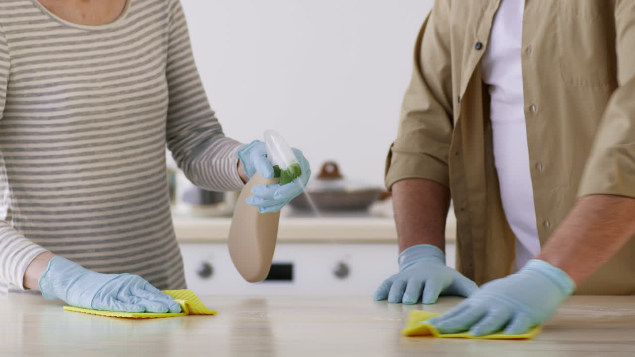 Couple Cleaning Kitchen Counter