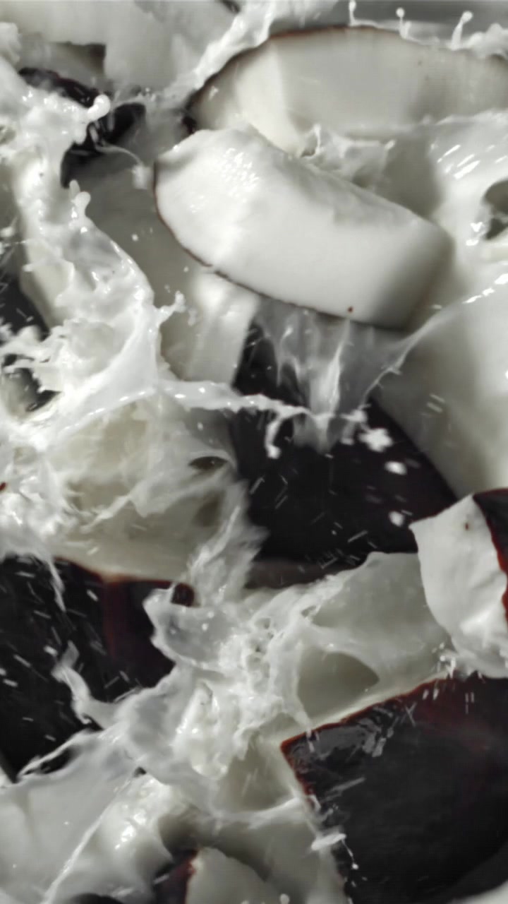 Pezzi di Cocco Fresco che Schizzano nel Latte Bianco al Rallentatore