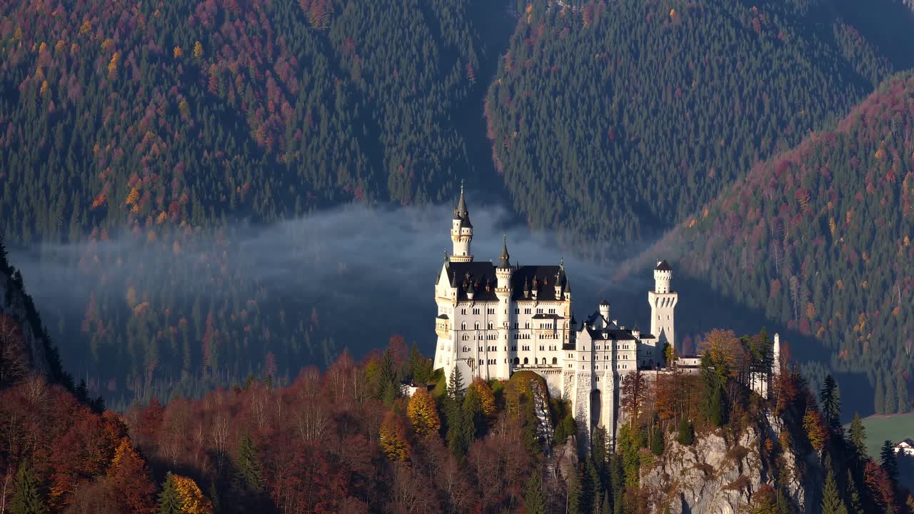 Castello maestoso su una collina circondato da una foresta autunnale, ripreso dall'alto