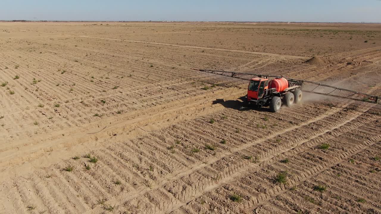 tractor rociando la tierra agrícola con un rociador agrícola montado durante un día soleado en ucrania, ciudad de kiev, tiro en órbita aérea
