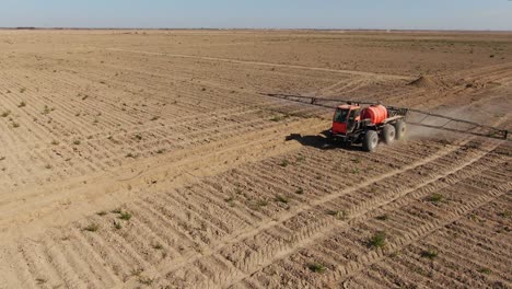 trattore che spruzza il terreno agricolo con spruzzatore agricolo montato durante la giornata di sole in ucraina, città di kyiv, ripresa aerea in orbita