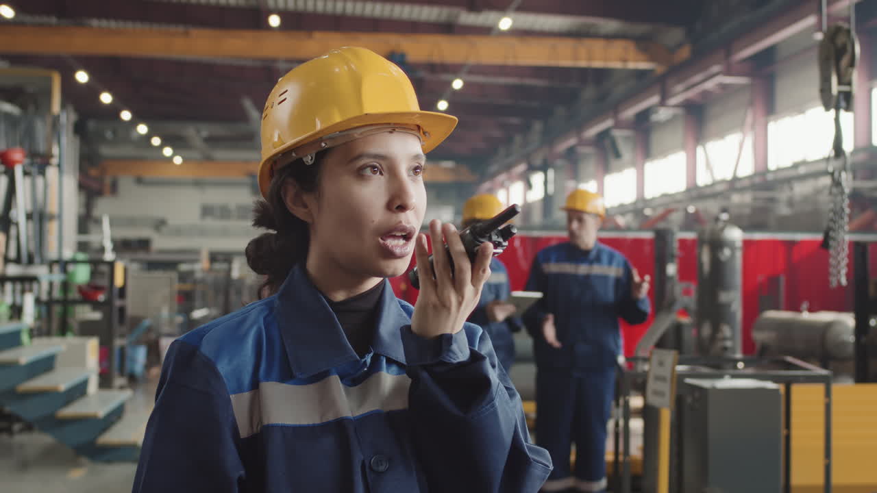 Female Plant Supervisor With Walkie-Talkie At Workplace