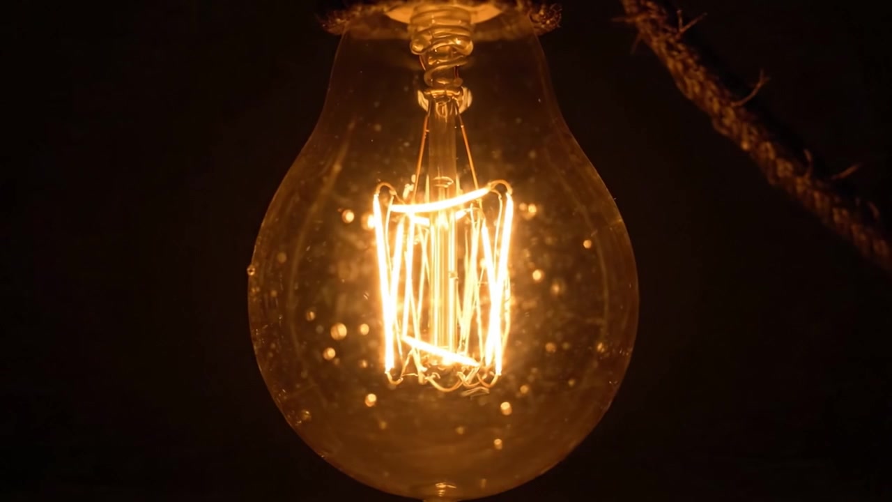 Splendida Lampadina Illuminata che Cattura l'Essenza del Calore e dell'Atmosfera con un Intricato Design del Filamento in un Ambiente Scuro