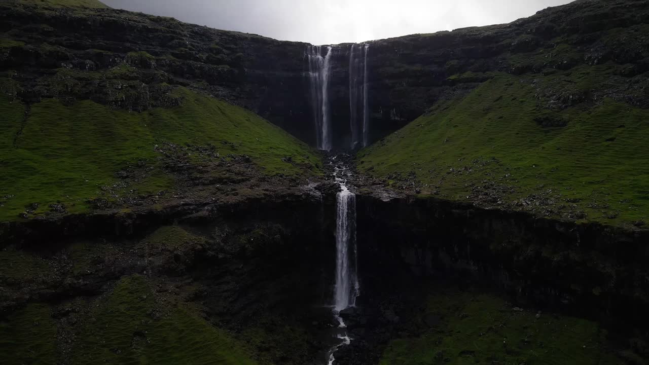 una vista impresionante de la cascada de fossa en las islas feroe, que cae en cascada por escarpados acantilados en exuberantes valles verdes, mostrando la belleza natural y la serenidad de este pintoresco destino nórdico.