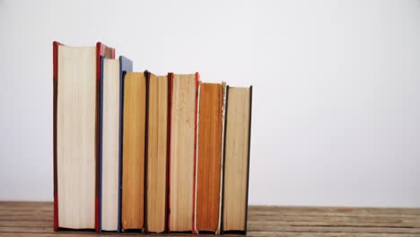 libros dispuestos en una mesa de madera 4k