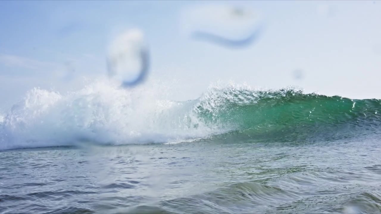 Dynamic water level shot in Tarifa, Spain capturing breaking waves, rolling barrels, white water and crystal clear turquoise Atlantic water with immersive ocean perspective.