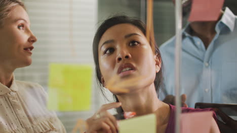 professional businesspeople discussing while writing on the whiteboard in modern office in slow moti