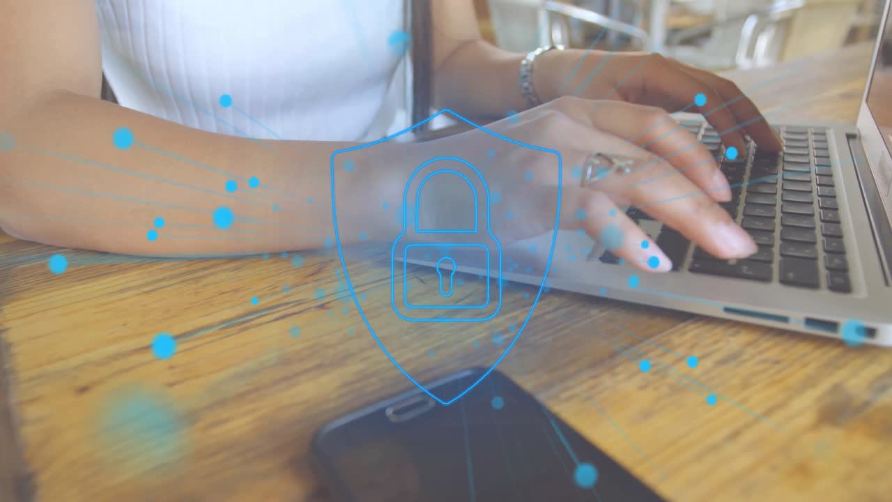 animación de puntos alrededor del candado en el escudo, sección media de una mujer biracial usando una computadora portátil