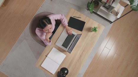 mujer trabajando desde casa en una computadora portátil