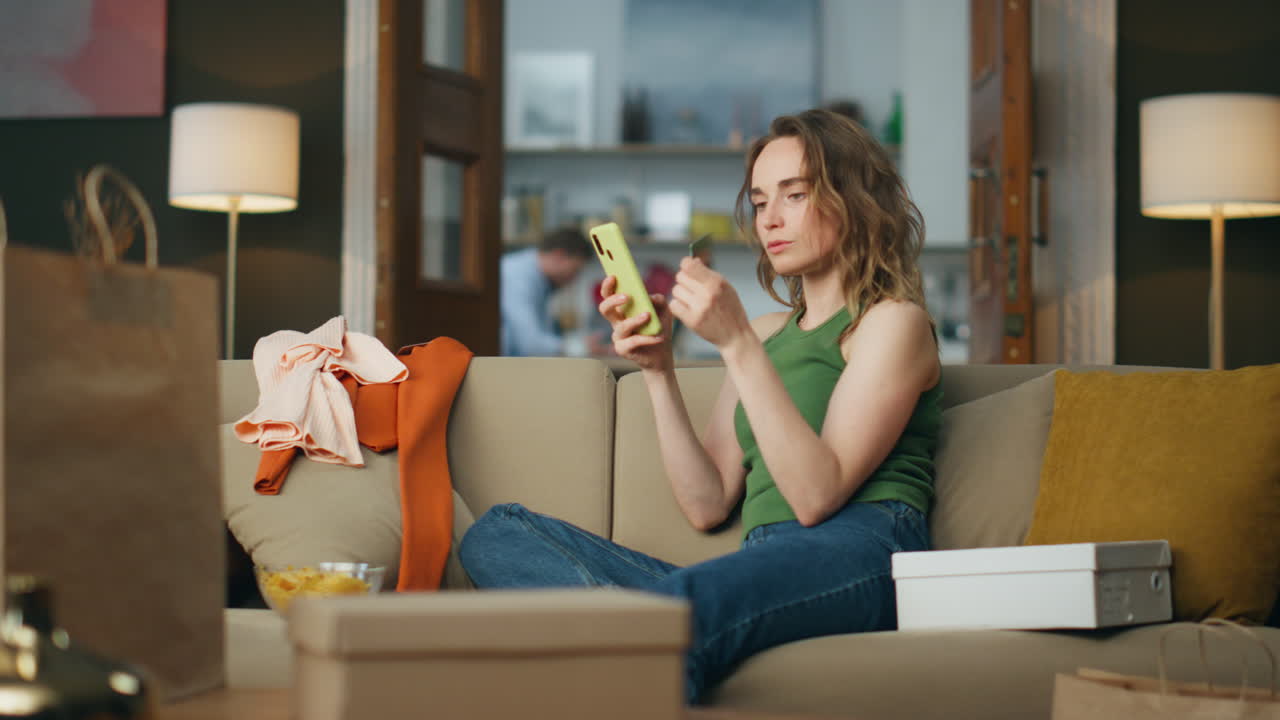 Involved woman shopping cellphone at home. Young customer paying credit card