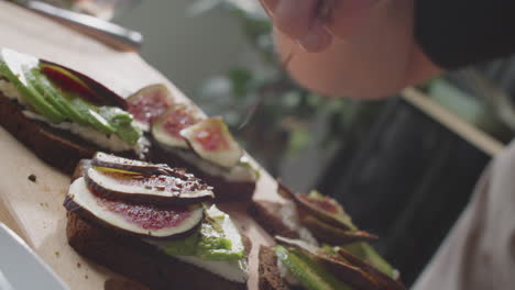 preparing delicious fig and avocado toast