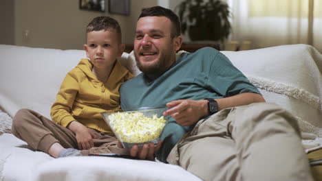 Family-sitting-on-the-sofa-and-watching-movie