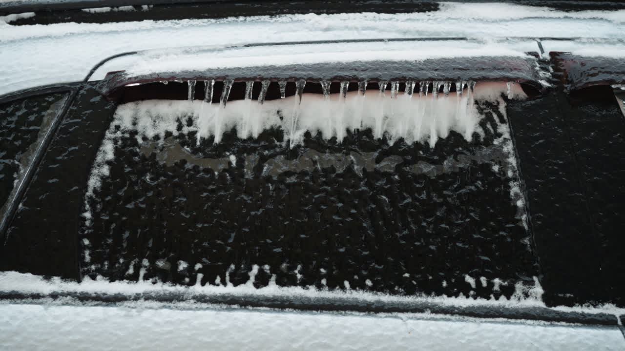 primer plano de un coche cubierto de nieve y hielo en invierno, mostrando las fuertes nevadas y patrones de heladas en el vehículo y la ventana