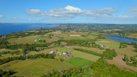 Disparo-De-Drones-Sobre-Campos-Y-Naturaleza-Rural-En-La-Soleada-Isla-Lemuy,-Chiloé,-Chile