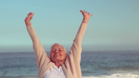 mujer mayor feliz levantando las manos