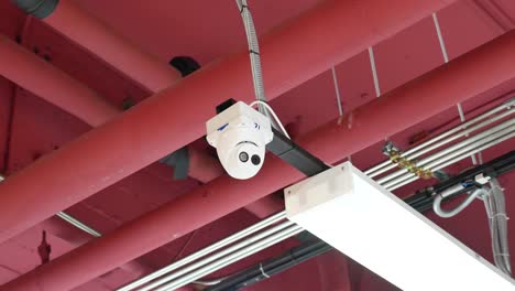 white indoor security camera, surveillance hanging on ceiling