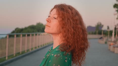 woman with red curly hair at sunset