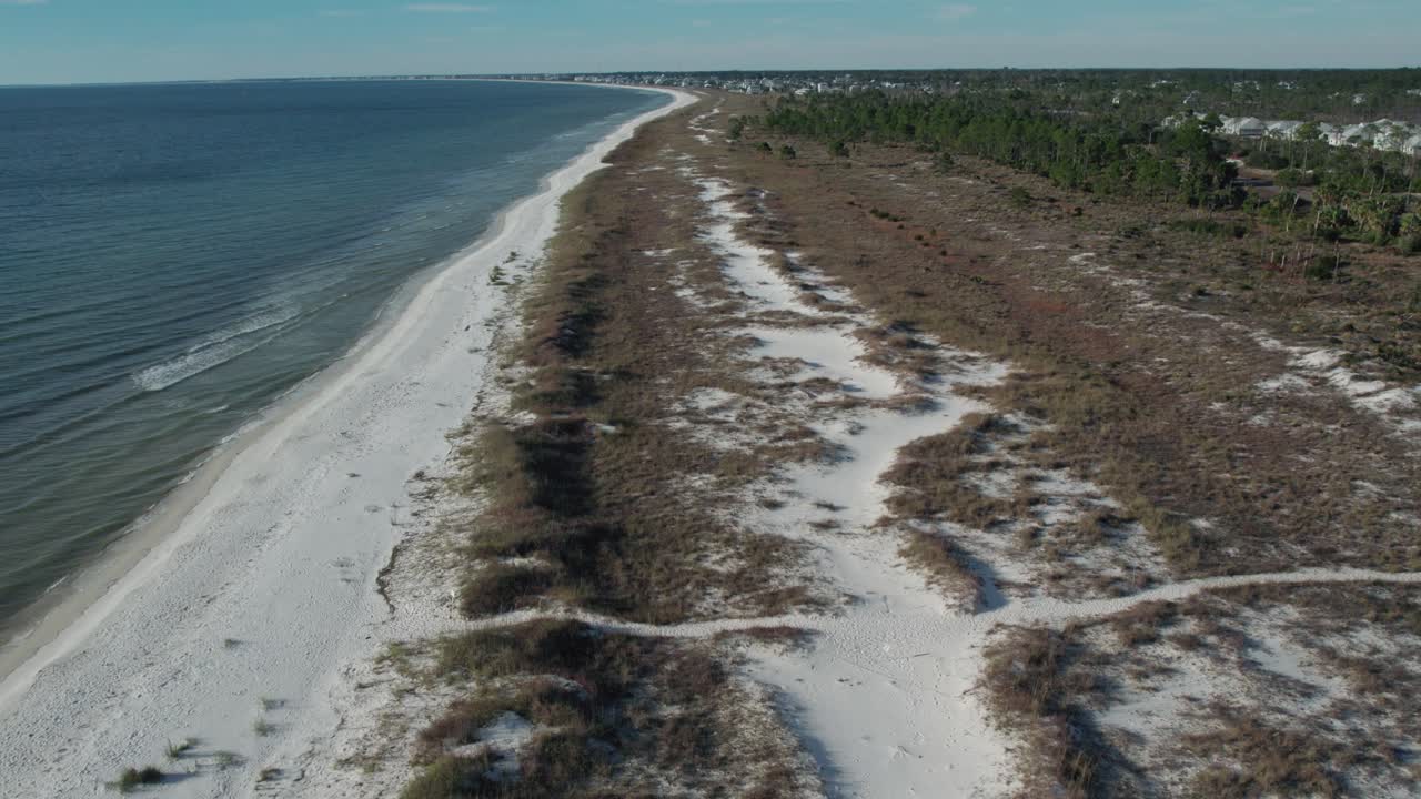 Low flight along a natural Florida beach at natural erosion protection of hills and beach grasses and plants