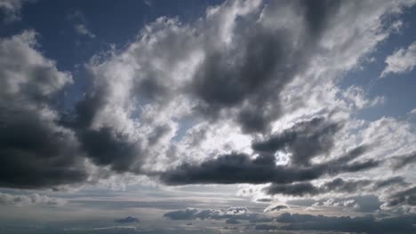 aerial left to right shot sky with dark grey clouds covering sun foggy landscape