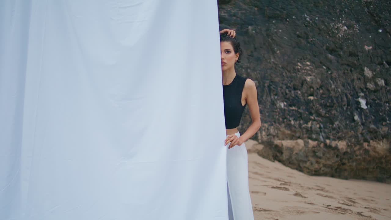 해변에서 휴식을 취하는 매력적인 소녀. 전문 패션 모델이 카메라를 찾고 있습니다.