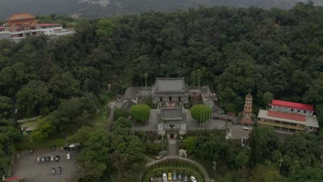 Lush,-dense-mountain-pagoda-tower-rooftops---decorative-colourful-temple-outside-Taipei,-China