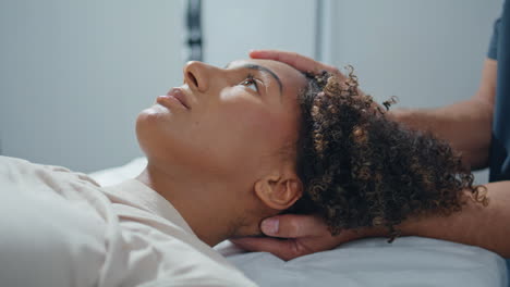 woman lying physiotherapy couch closeup. clinic patient opening eyes with relief