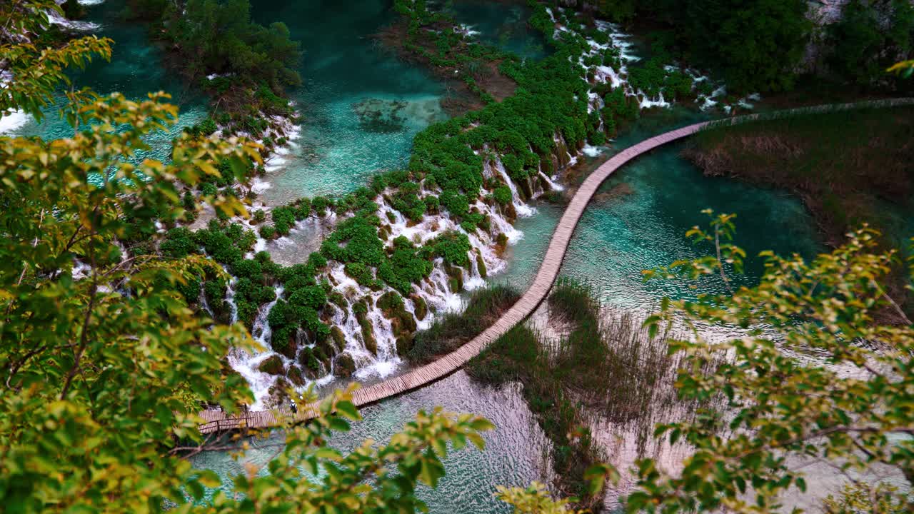 Natural turquoise pools with waterfalls flowing over rock terraces, footpath. Plitvice Lakes Croatia