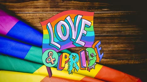 animation of rainbow love and pride over rainbow lying on wooden background