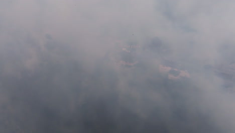 aerial drone footage of a neighborhood in georgia that is covered in smoke from a nearby forest fire.