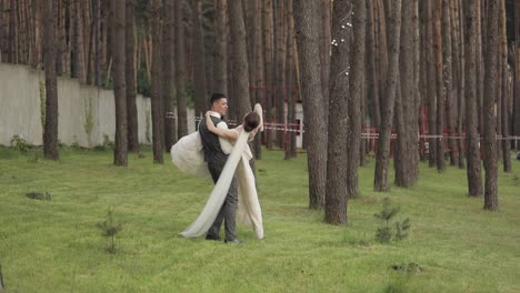 lovely newlyweds caucasian bride groom dancing in park, making kiss, wedding couple family