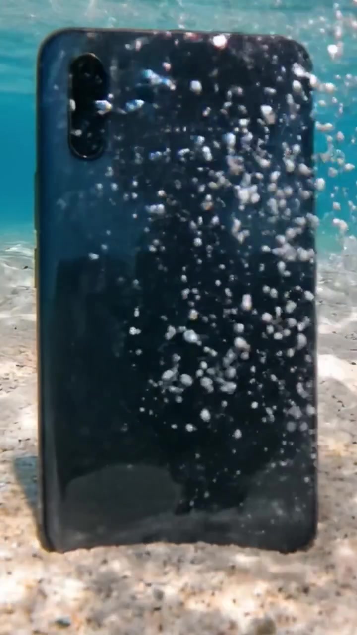 Smartphone subacqueo: catturare l'estetica unica di un telefono sommerso in acqua limpida, mostrando riflessi e un ambiente tranquillo.