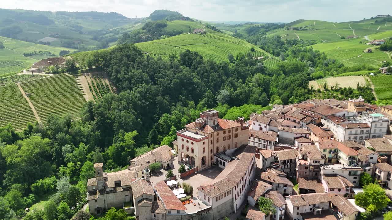 Barolo Castle in Langhe Wine Region, Cuneo, Piedmont, Italy. 4K Aerial view of the village and the vineyards, spiral forward to the casle.