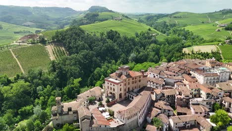 barolo castle in langhe wine region, cuneo, piedmont, italy. 4k aerial view of the village and the vineyards, spiral forward to the casle.